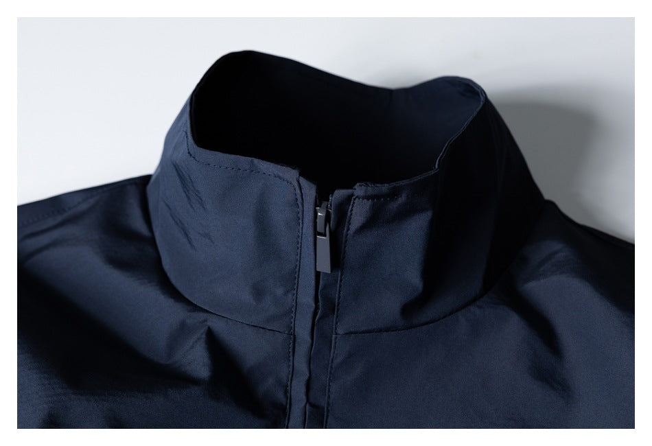Close-up of a dark navy jacket's stand collar and front zipper.