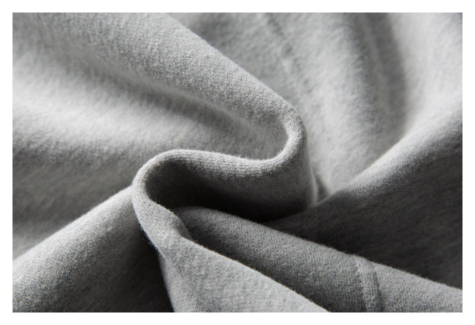 Macro view of folded light gray sweatshirt fabric showing its surface and drape.