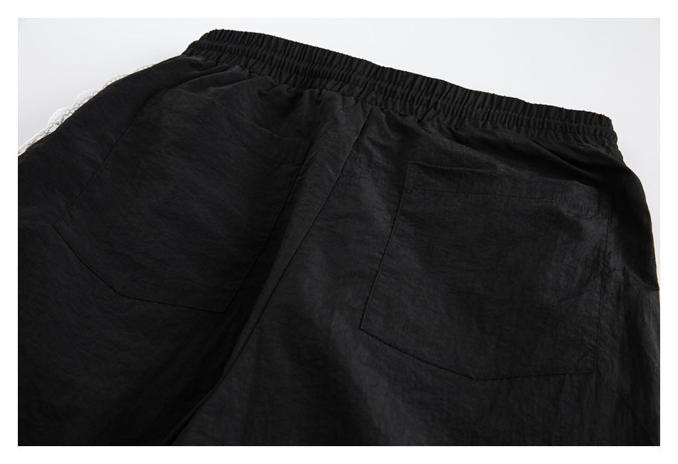 Back view of black pants with an elastic waistband and two large patch pockets.