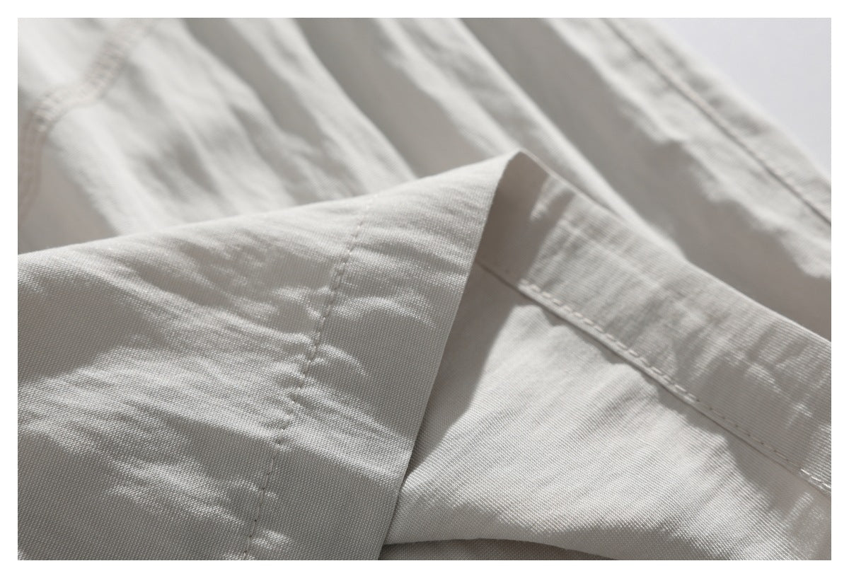 Close-up of a folded cream garment edge with visible stitching.
