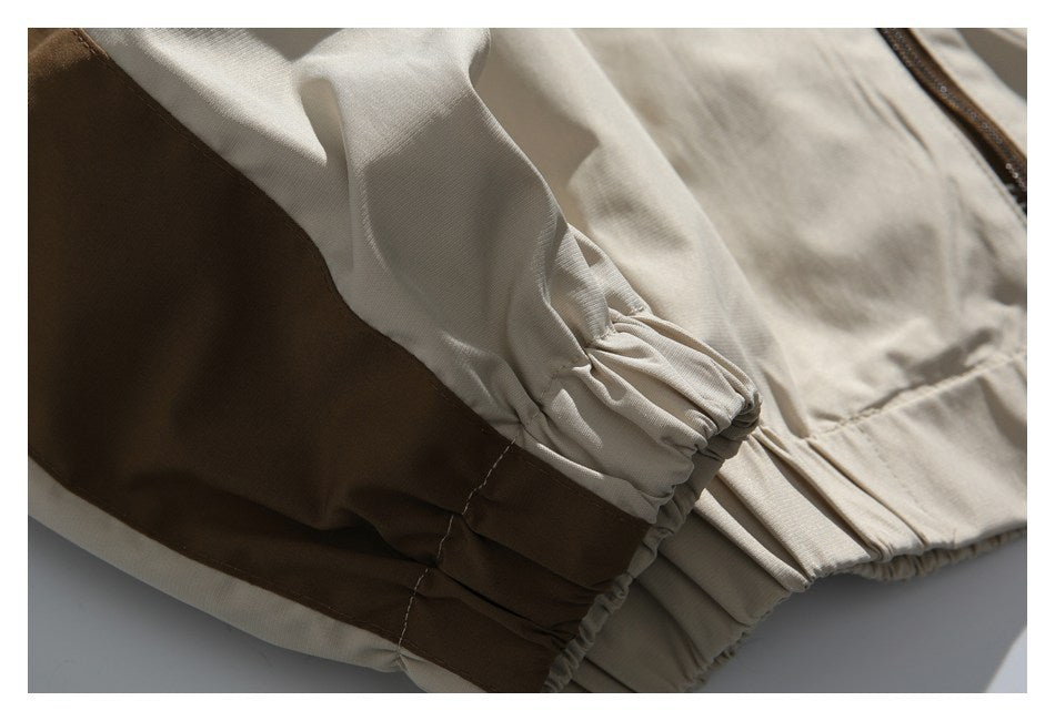 Close-up of the beige jacket’s gathered elastic cuff and hem, with a brown contrast panel.