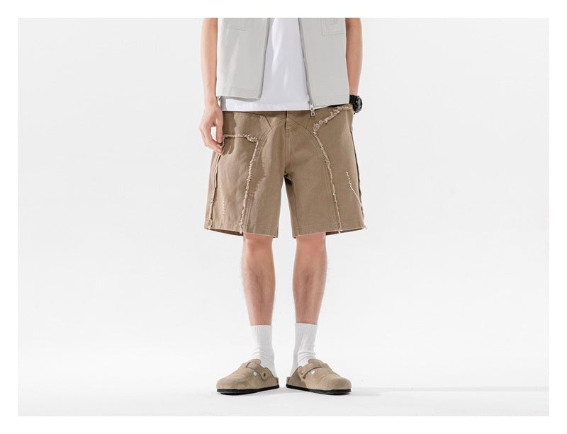 Model wearing tan knee-length shorts with frayed seam detailing, shown from the front.