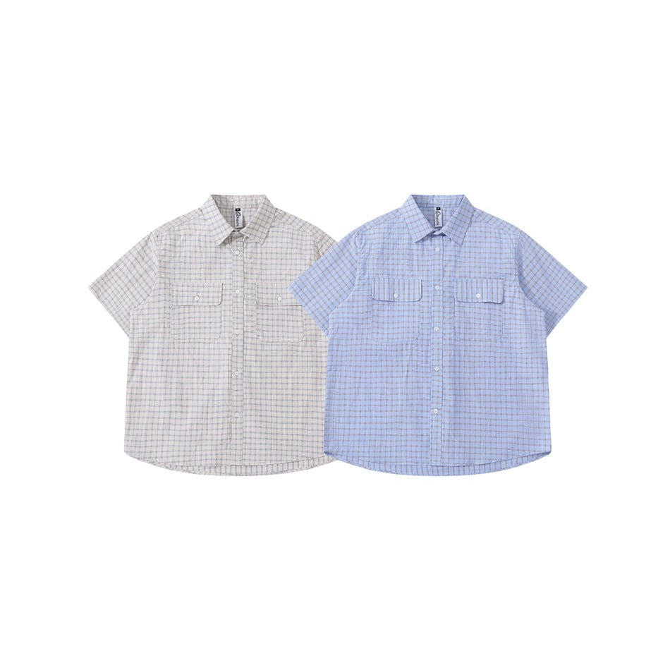 Two short-sleeve plaid button-up shirts shown from the front in light gray and light blue, each with two chest pockets.