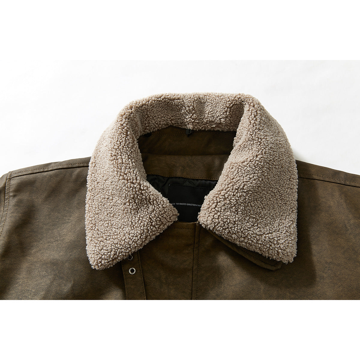 Close-up of a brown jacket's front collar, showing a thick beige fleece collar and snap fastening.