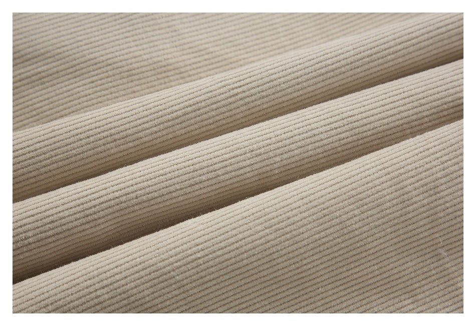 Macro view of the garment's cream fabric with narrow raised parallel ribs.
