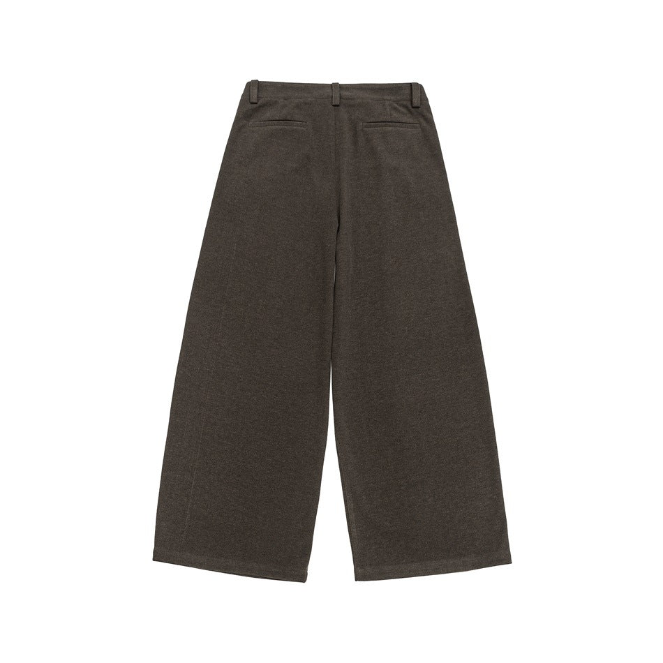 Back view of brown wide-leg trousers with belt loops and two welt pockets.