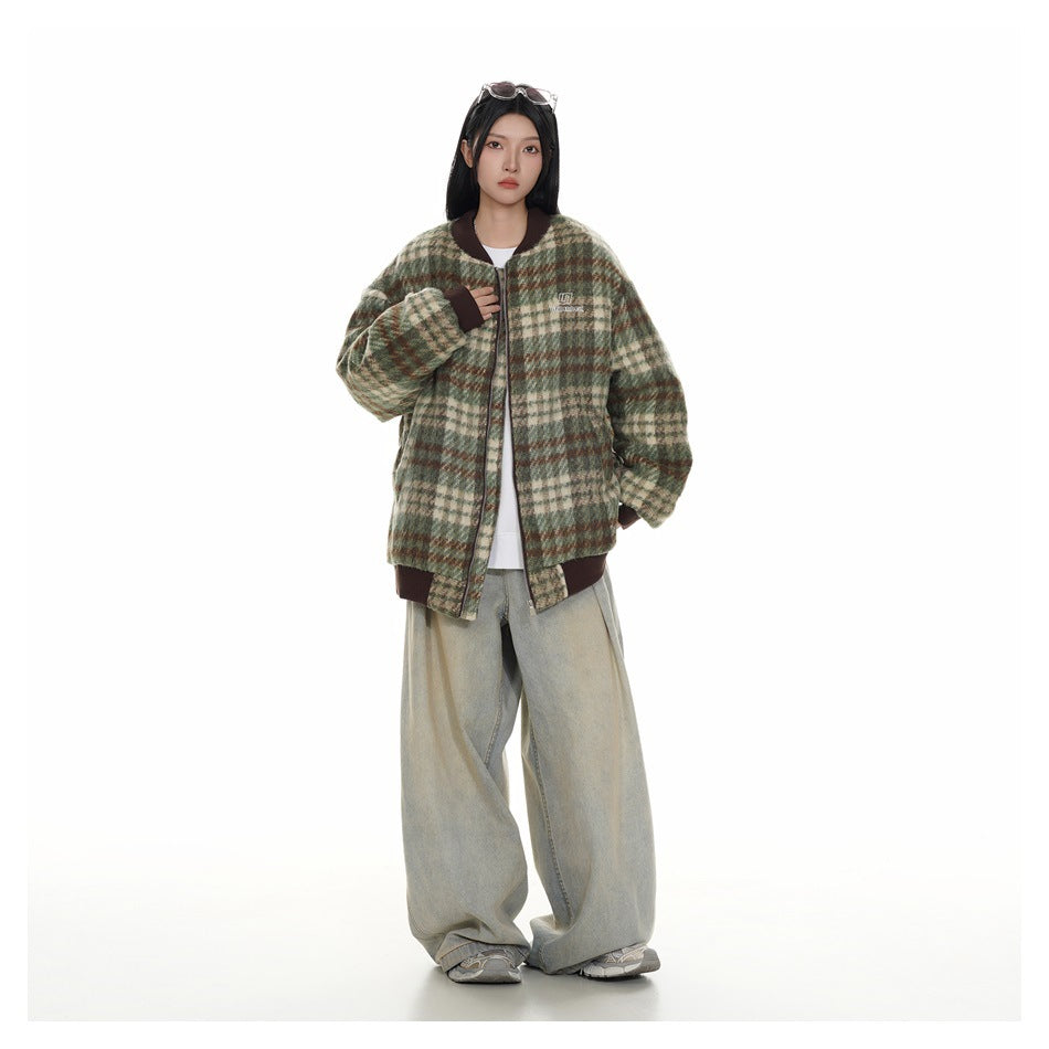 Full-length view of a model wearing an oversized green plaid bomber jacket with a white top and wide-leg jeans