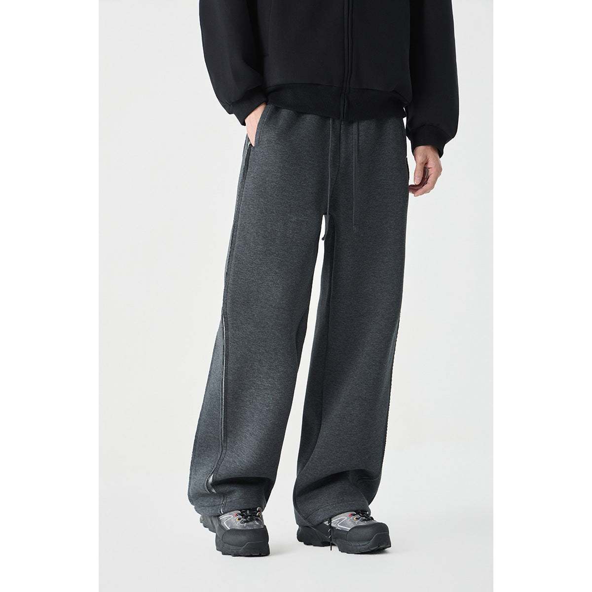 Model wearing charcoal wide-leg pants with a drawstring waist and long side seams, shown from the front.