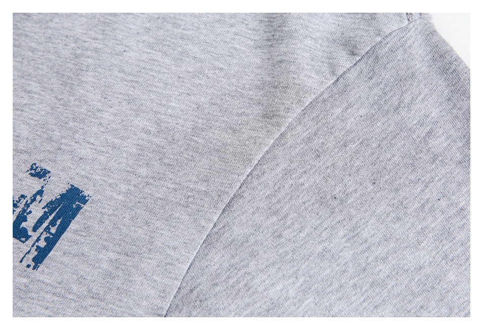 Close-up of the heather gray top's sleeve seam and a cropped portion of its blue print.