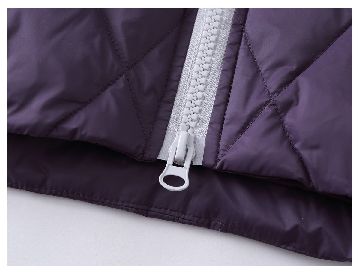 Close-up of the light gray main zipper and stitching on a dark purple quilted garment.