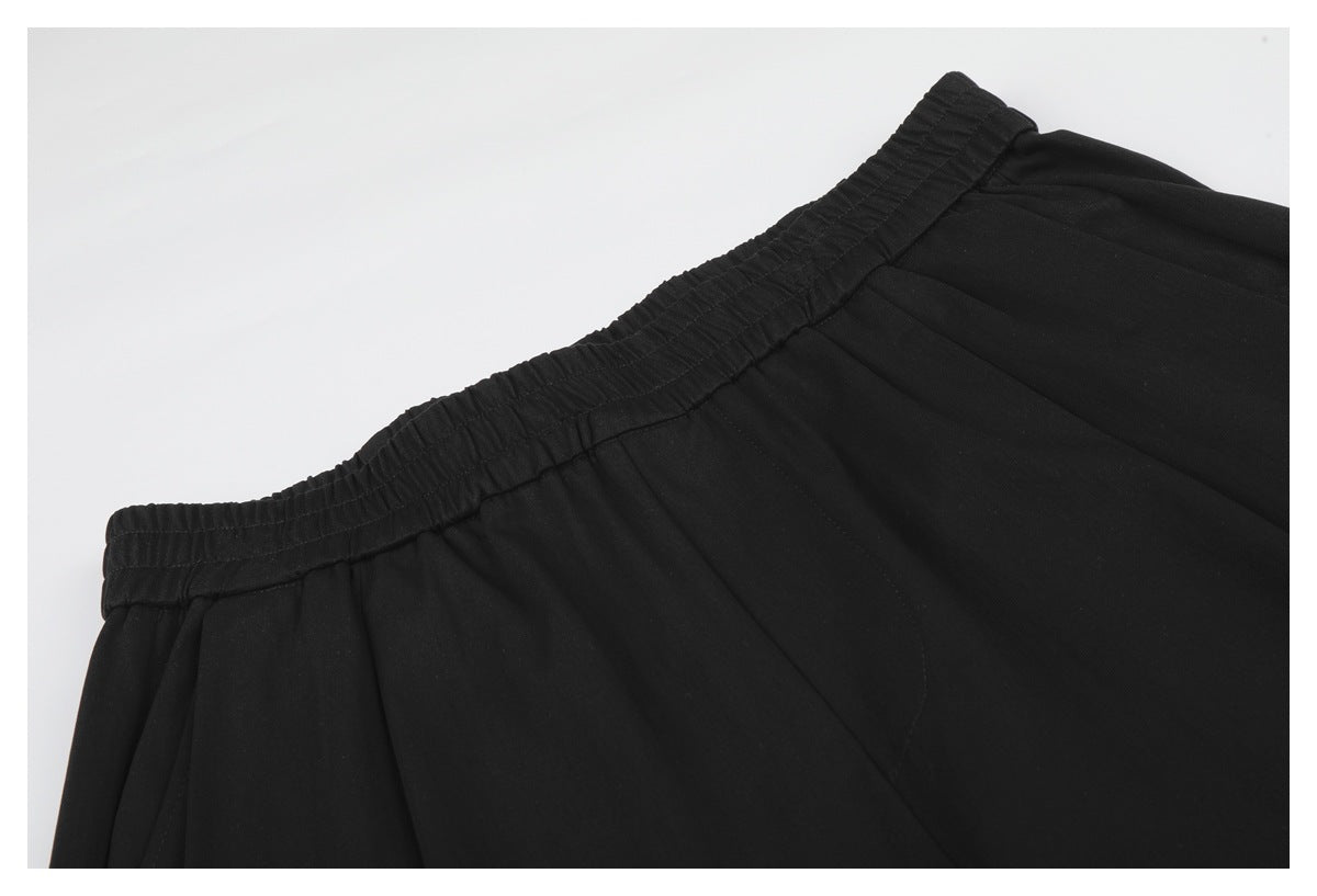 Close-up of black shorts showing the gathered elastic waistband and stitching.