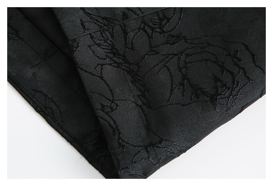 Close-up of the black floral-patterned garment's stitched edge and folded hem.