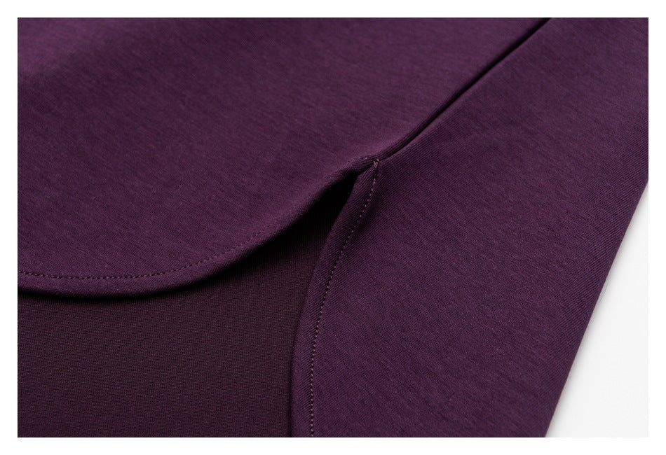 Close-up of the plum shirt's curved hem and adjoining stitched seam.