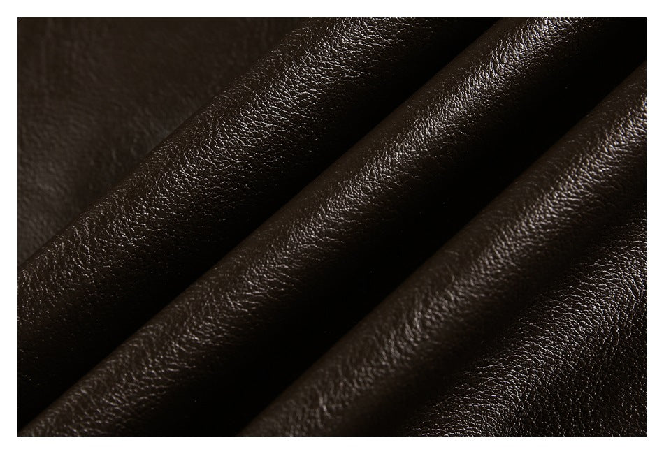 Close-up of dark brown pebbled material arranged in soft folds, with a glossy finish.