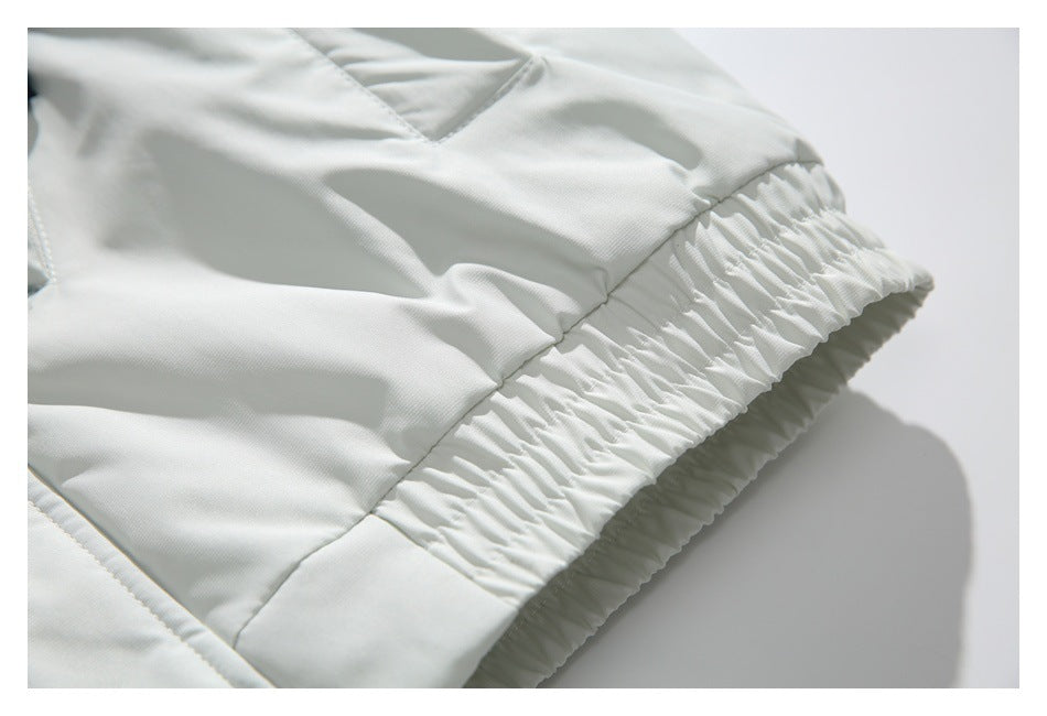 Close-up of the white jacket's gathered elastic hem and side seam.