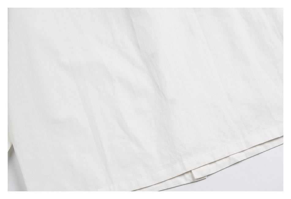 Close-up of a white garment's stitched hem and layered edge.