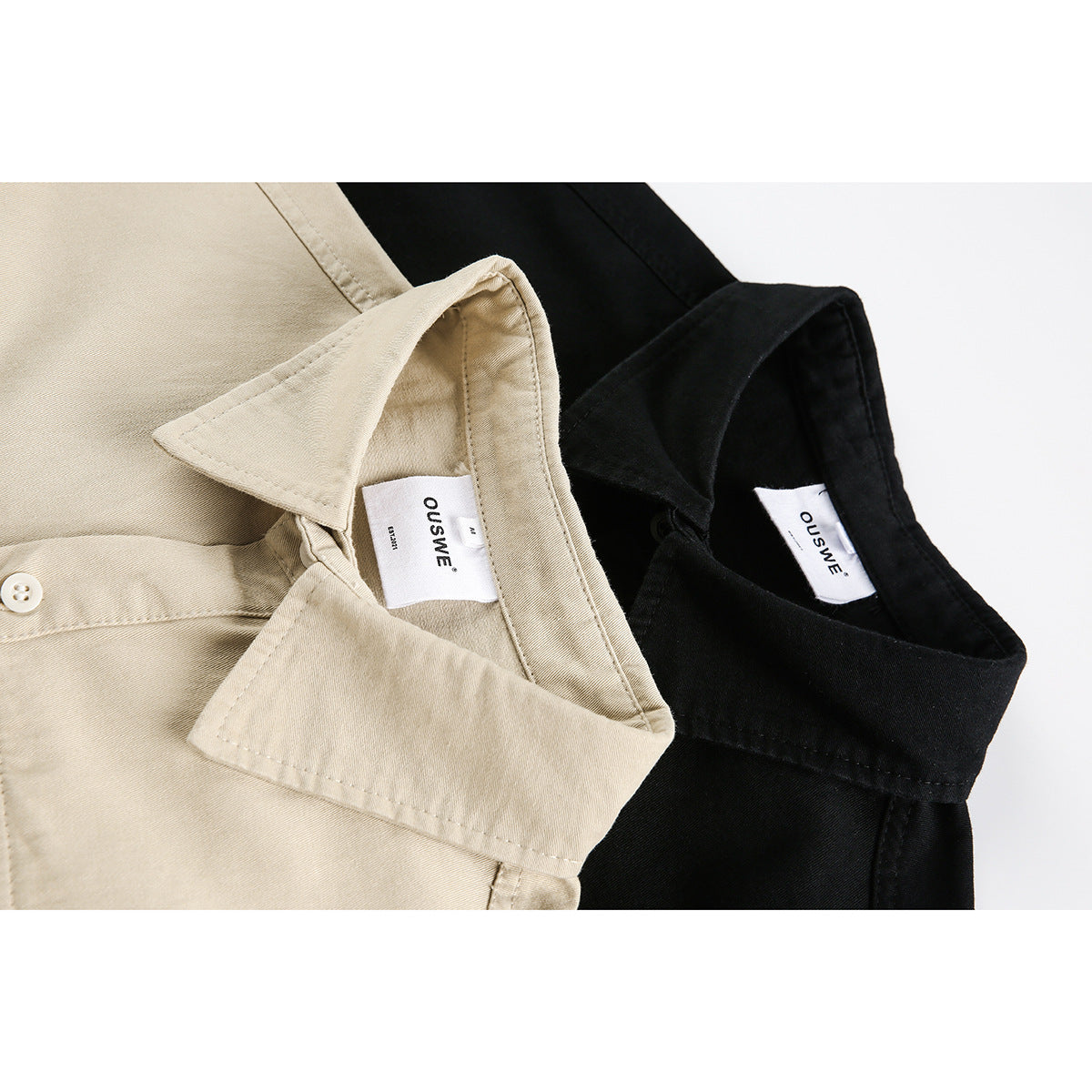 Close-up of beige and black short-sleeve shirts showing their pointed collars, button plackets and neck labels.