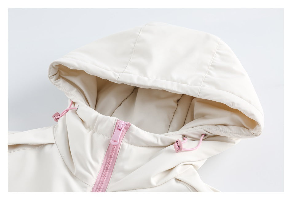 Close-up of an ivory jacket hood with pink drawcords and a pink front zipper.