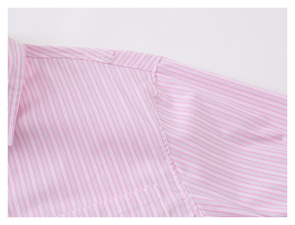 Close-up of the shoulder seam and sleeve on a pink and white striped shirt.