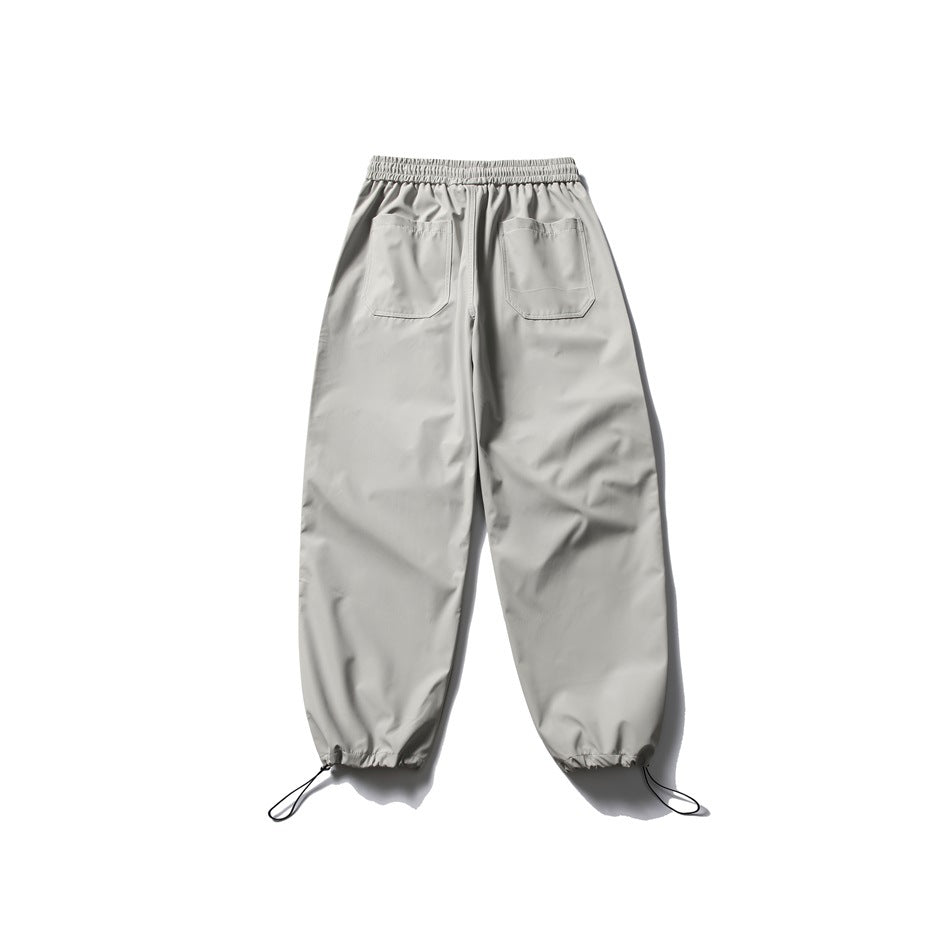 Rear view of light gray jogger pants with an elastic waist, two back pockets, and drawcords at the cuffs.