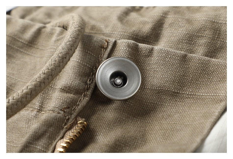 Close-up of a metal snap and braided drawstring on taupe shorts.