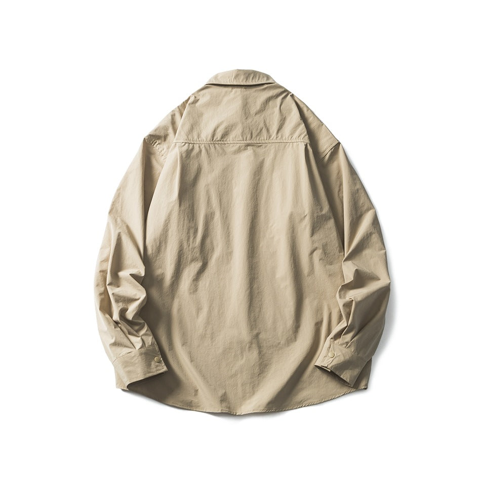 Back view of a beige long-sleeve shirt with a pointed collar, back yoke, button cuffs, and curved hem.