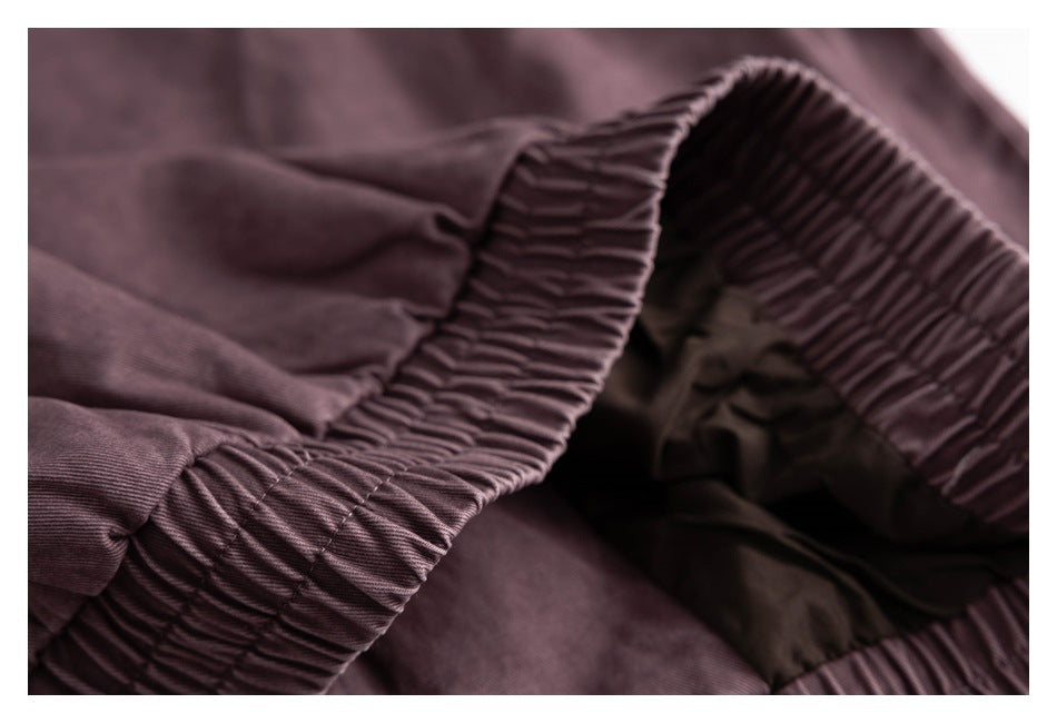 Close-up of a gathered elastic waistband on a dusty mauve garment.