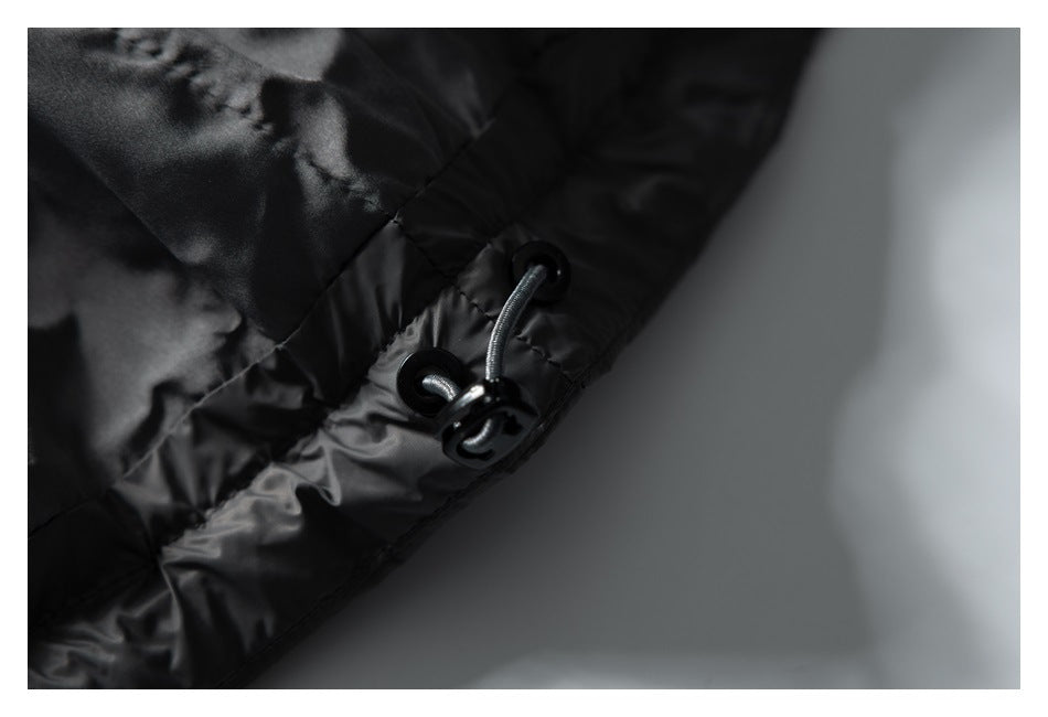 Close-up of a black padded garment's elastic drawcord and adjustment toggle.