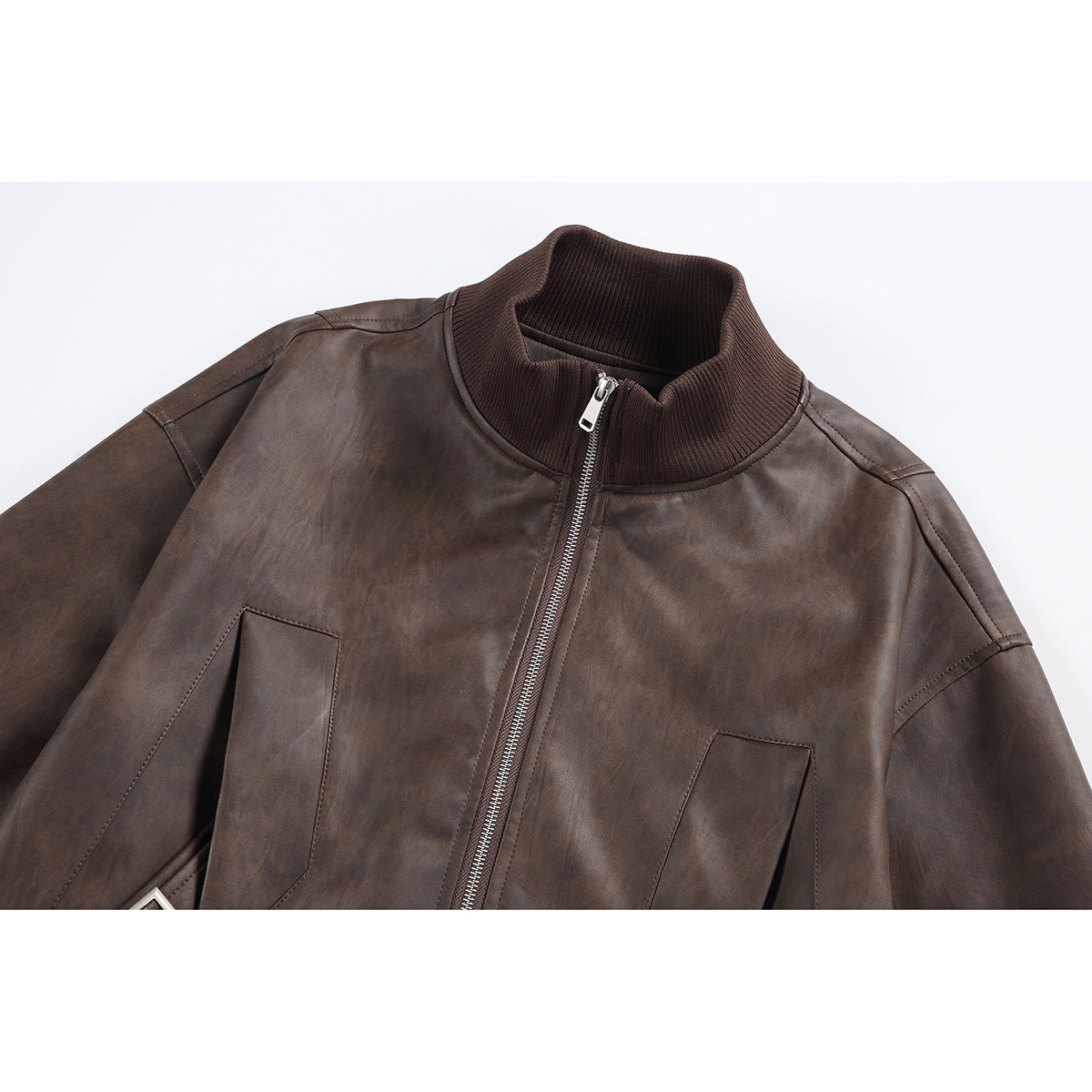 Close-up of a dark brown zip-front jacket with a ribbed stand collar and angled front pockets.