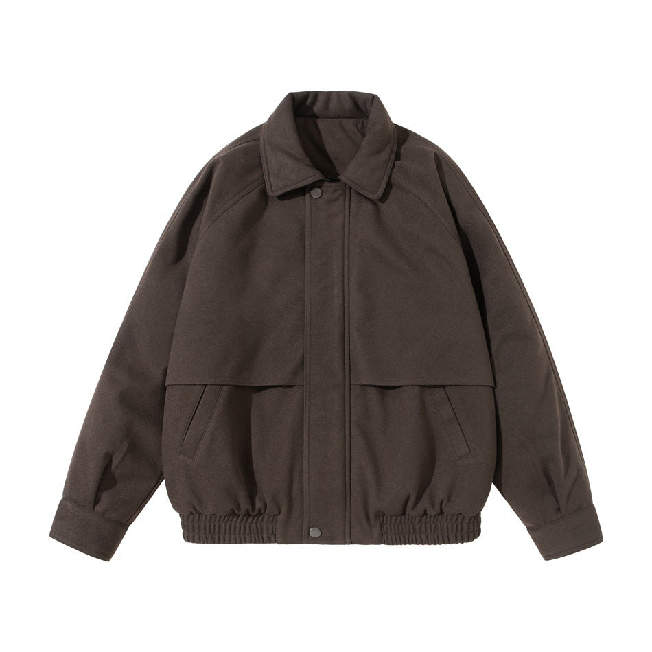 Front view of a dark brown jacket with a pointed collar, snap front, raglan sleeves, flap, and elastic hem.