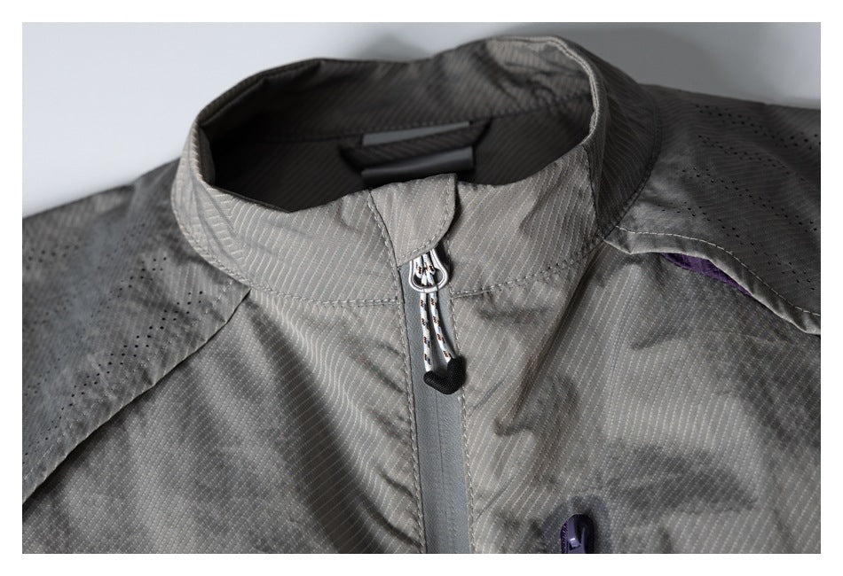 Close-up of the gray vest's stand collar, front zipper, and perforated shoulder panels.