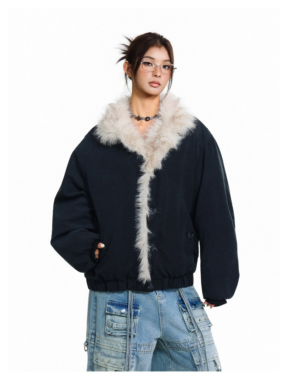 Model wearing a black cropped jacket with a large cream faux-fur collar and front trim.