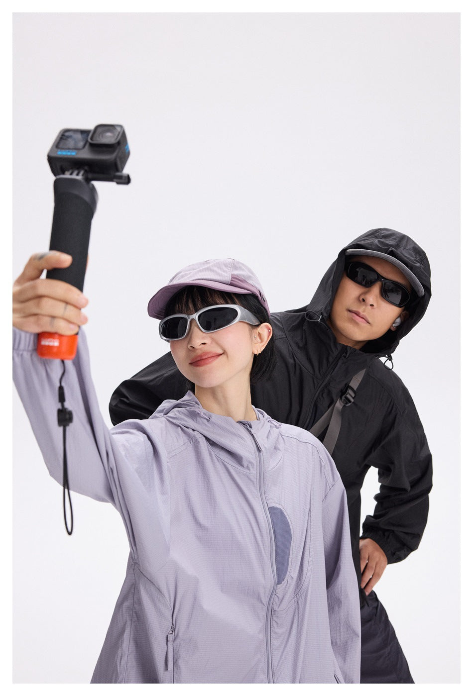 Close view of models wearing pale lavender and black hooded jackets.