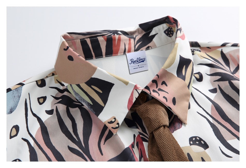 Close-up of the printed shirt collar, inner label, and brown textured tie.
