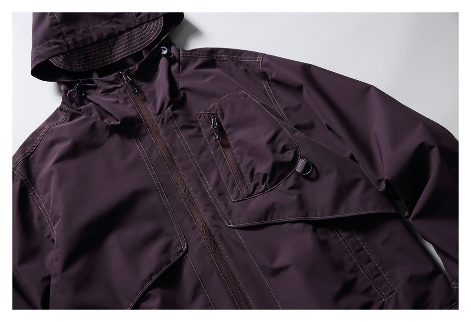Close view of a dark plum hooded jacket front with a full-length zipper and multiple zippered pockets.