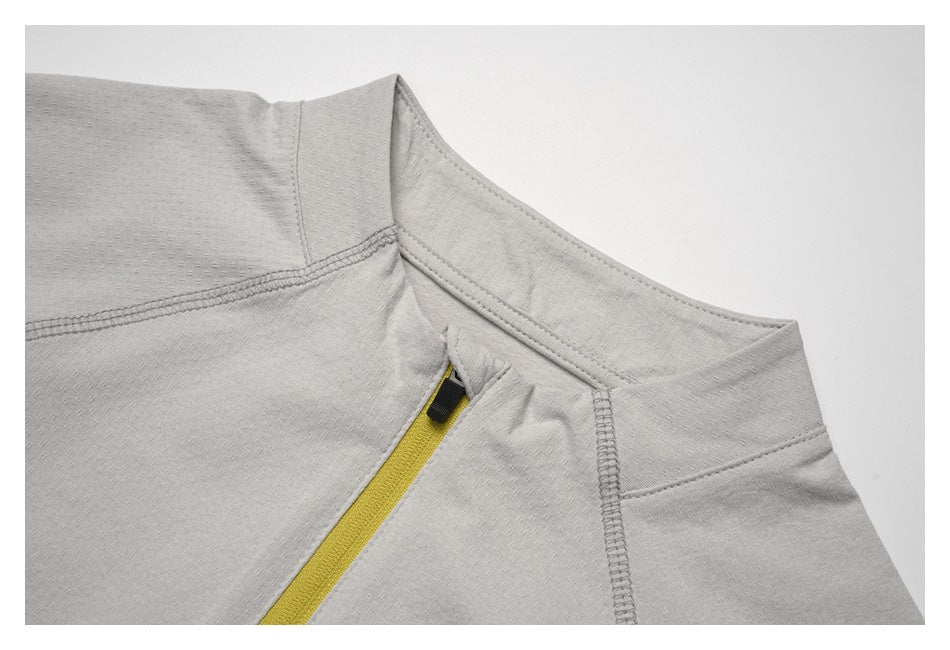 Close-up of a light gray top's neckline and yellow zipper with a black pull tab.