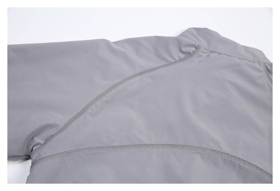 Close-up of curved seam lines across the back of a light gray pinstriped garment.