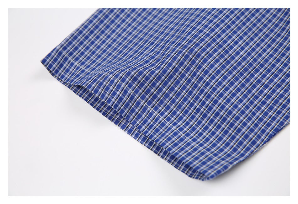 Close-up of the stitched edge and hem on a blue-and-white checked shirt.
