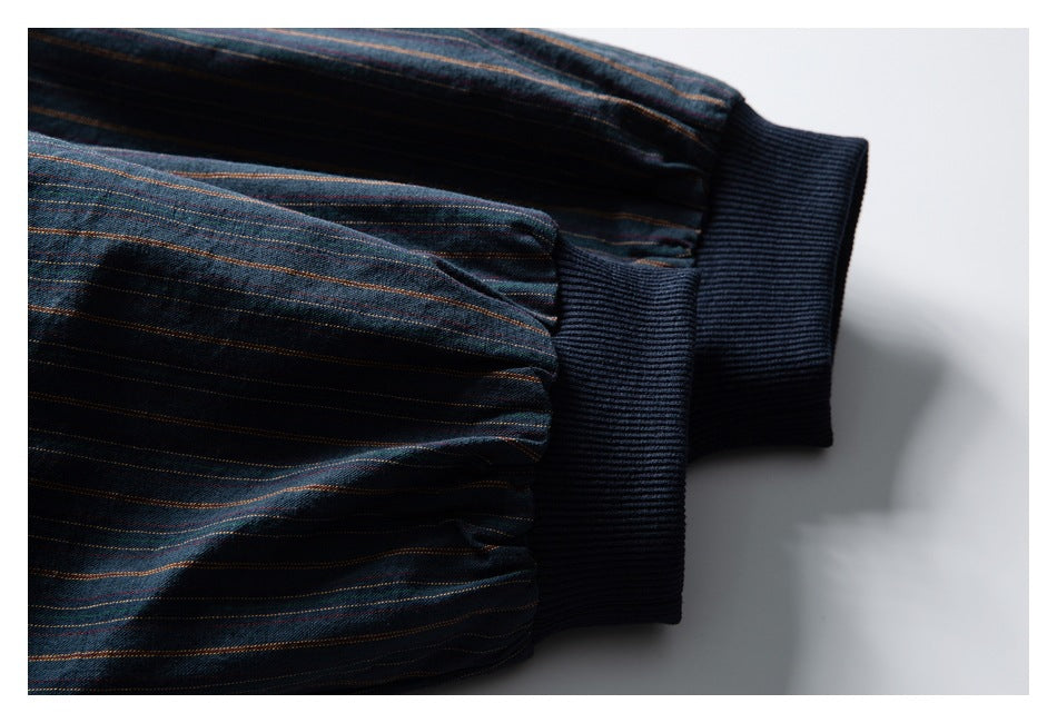 Close-up of gathered striped sleeves finished with dark navy ribbed cuffs.