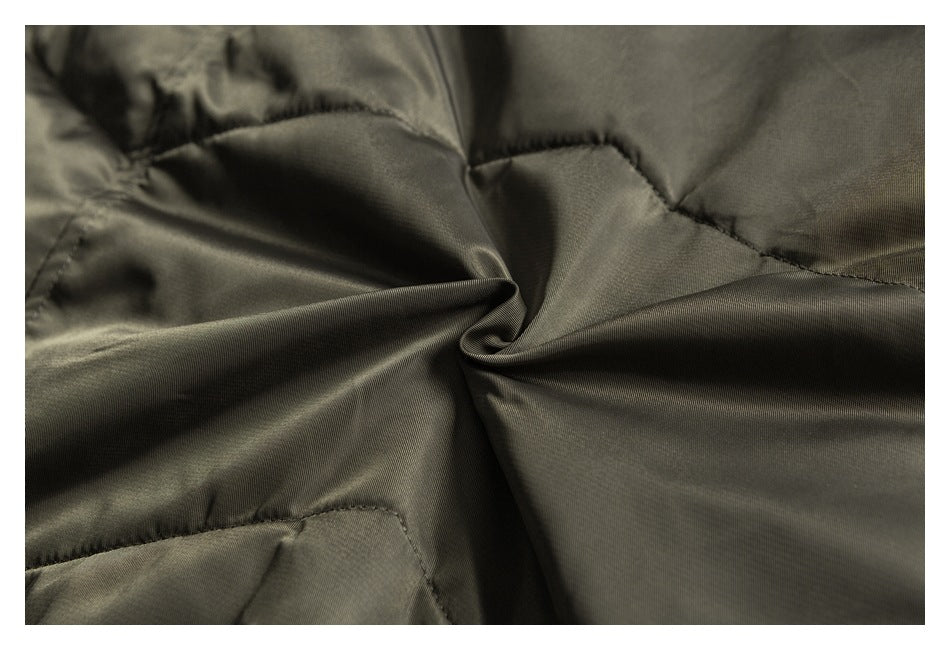 Close-up of smooth olive-gray jacket fabric gathered into folds.