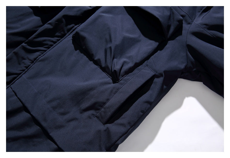 Close-up of a large flap pocket and seam on the dark navy jacket.