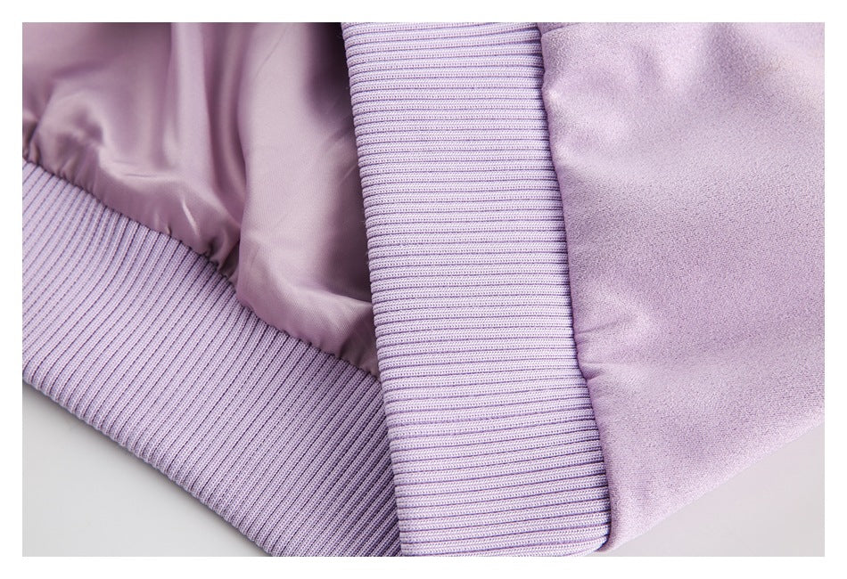 Close-up of a lavender garment showing wide ribbed trim beside smooth fabric.