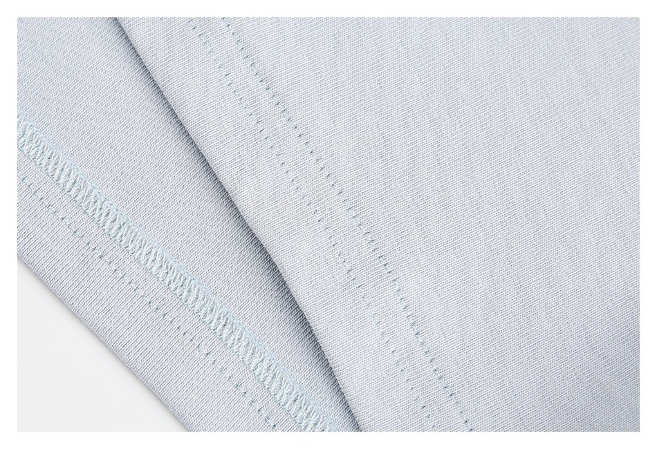 Close-up of pale blue knit garment fabric and a stitched seam edge.