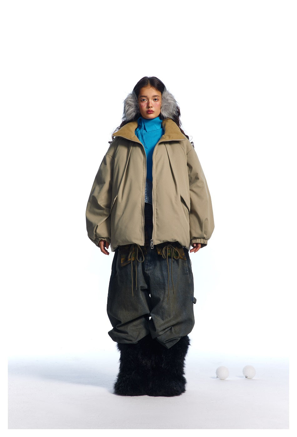 Front view of a model wearing an open taupe oversized jacket with a high collar and flap pockets.