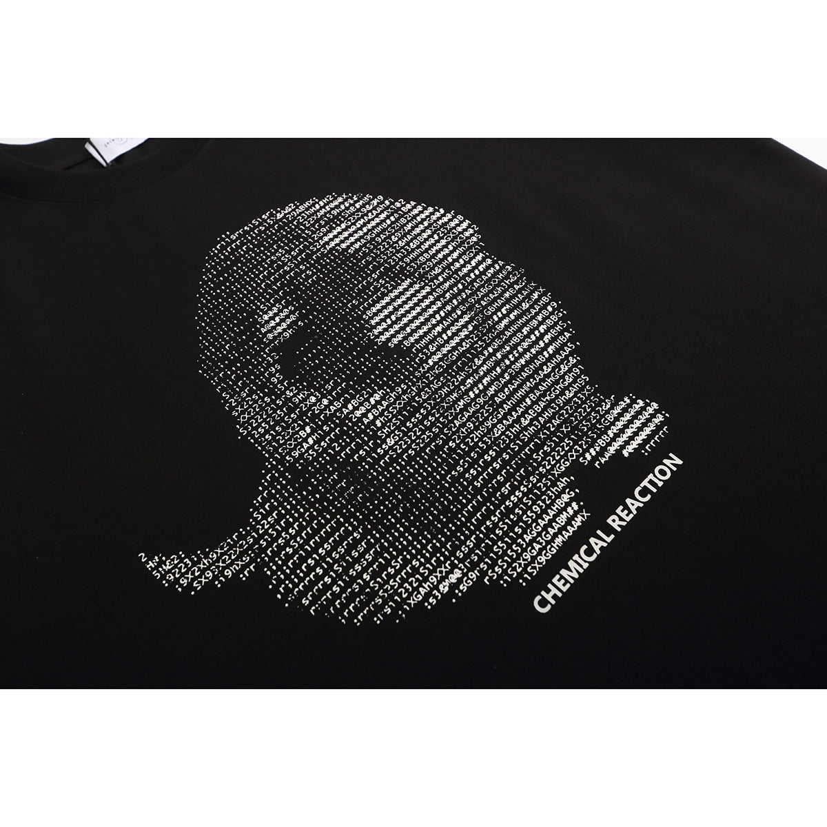 Close-up of a white typographic face graphic and Chemical Reaction lettering on a black T-shirt.
