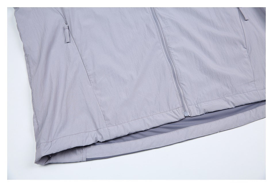 Close-up of the pale gray-lavender jacket's lower front, center zipper, side pockets, and contrasting inner hem panel.
