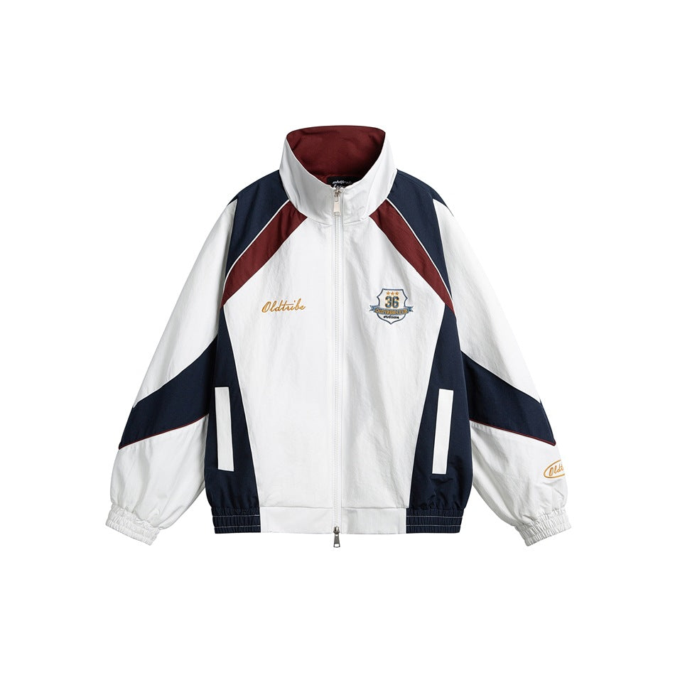 White zip-up stand-collar jacket with navy and burgundy color-block panels and an embroidered shield chest patch
