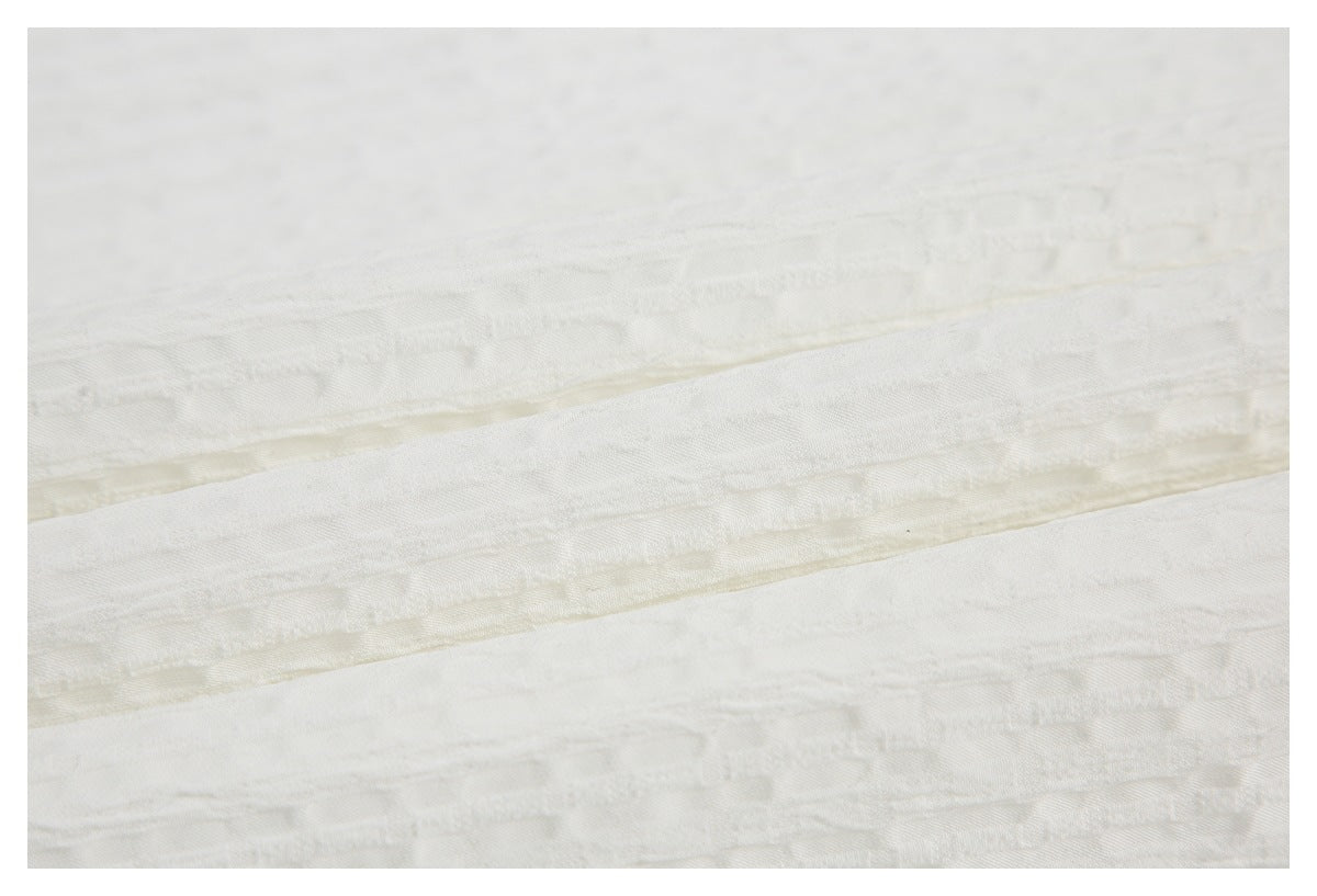 Close-up showing the subtle woven texture and layered folds of white fabric.