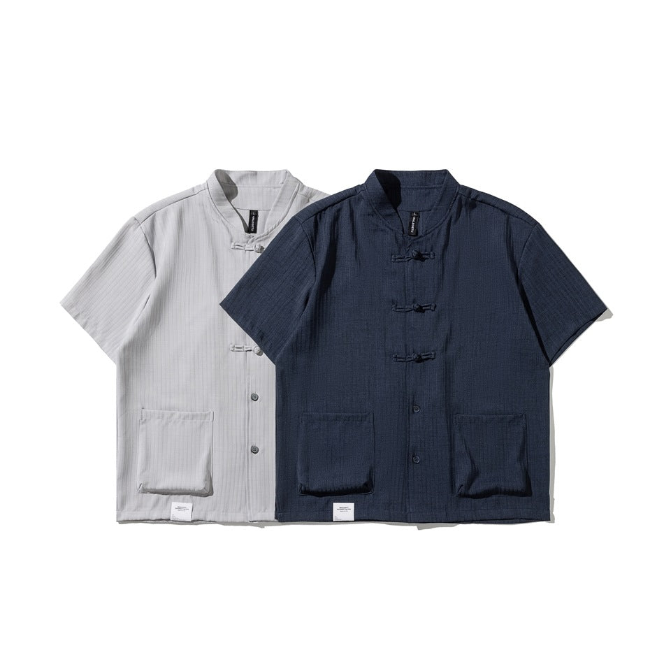 Light gray and navy short-sleeve shirts with stand collars, frog closures, buttons, and front patch pockets.