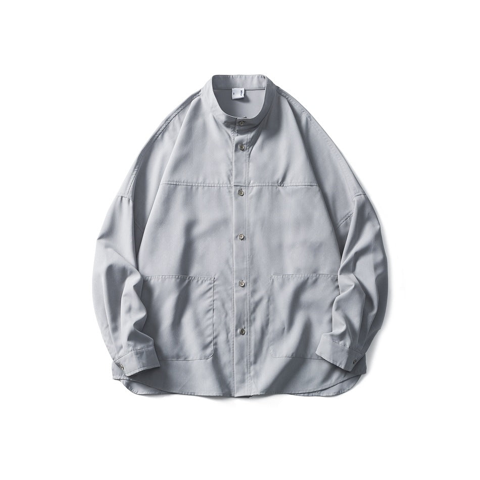 Light gray stand-collar button-front shirt flat lay with two large front patch pockets and chest seam